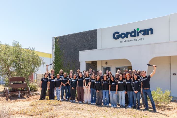 The Gordian Biotechnology team outside the company facility; Martin Borch Jensen’s full visible figure is marked by a twice-drawn green pen oval in the back row at left, raising a black blade